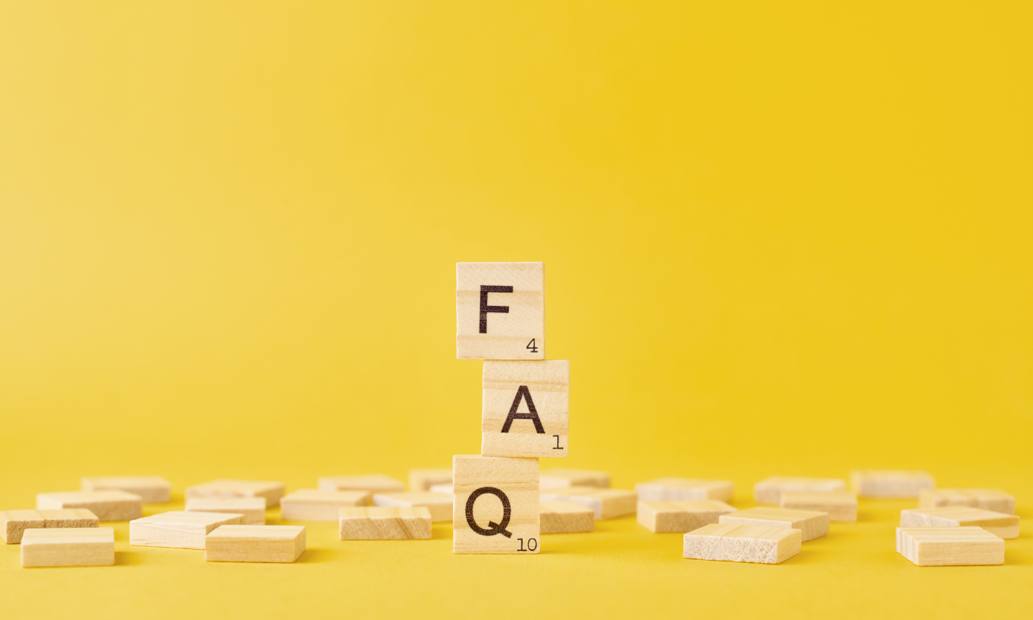 image with gold background and wooden scrabble tiles spelling out FAQ 