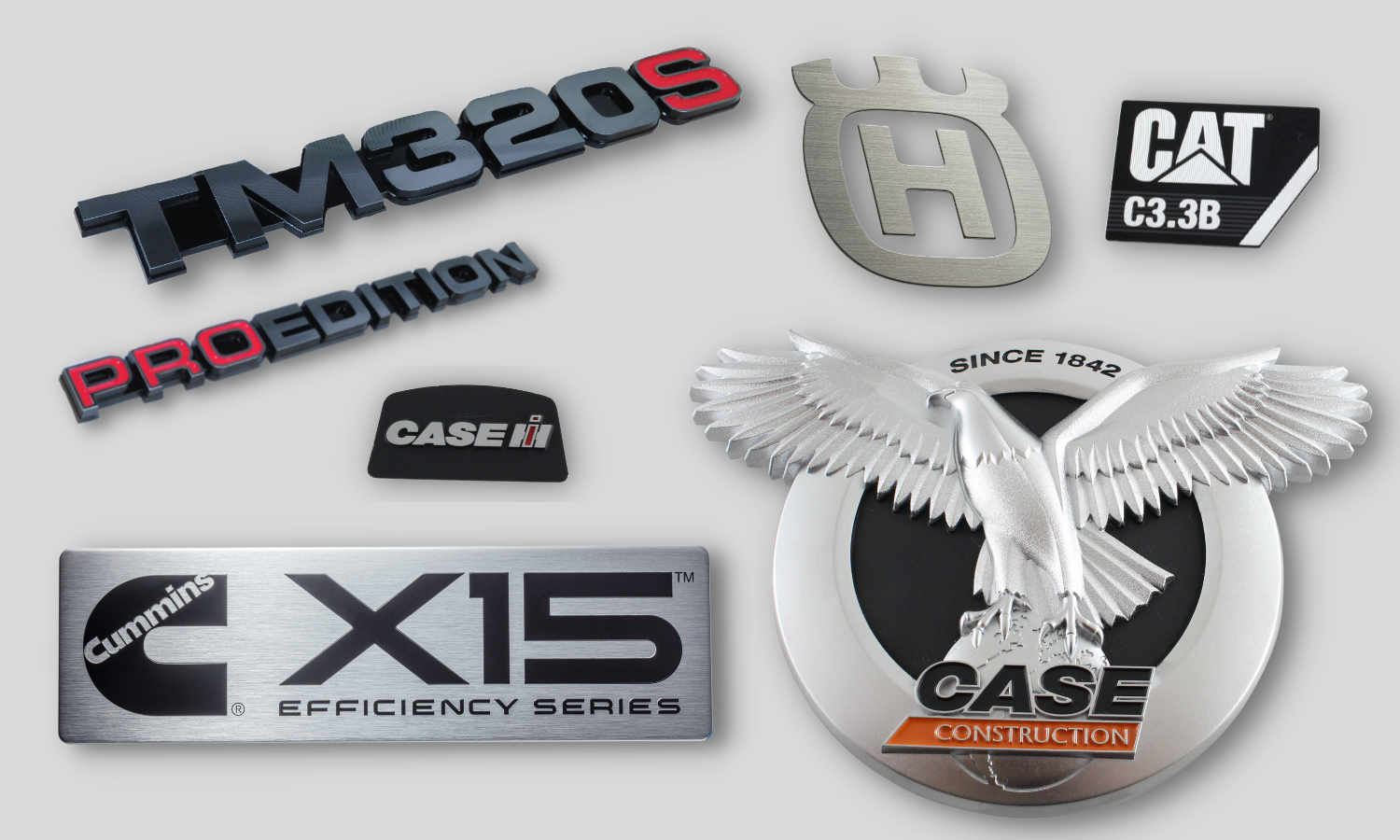 Collage of logos and name plates used on construction and agriculture machinery. Horizontally diamond cut chrome and red letters with black background TM320S and PROEDITION. Black trapezoid badge with raised CASE chrome letters. Large rectangle with horizontal brushing and recessed black text reading CX15 Efficiency Series. Circle badge with intricately detailed eagle with feathers and text reading CASE Construction. Horizontally brushed letter H. Black small rectangle with raised chrome CAT letters.